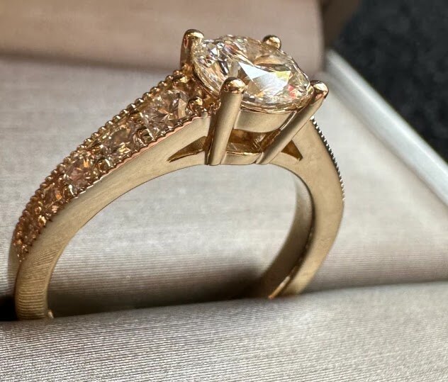 Yellow gold engagement ring with side stones in box