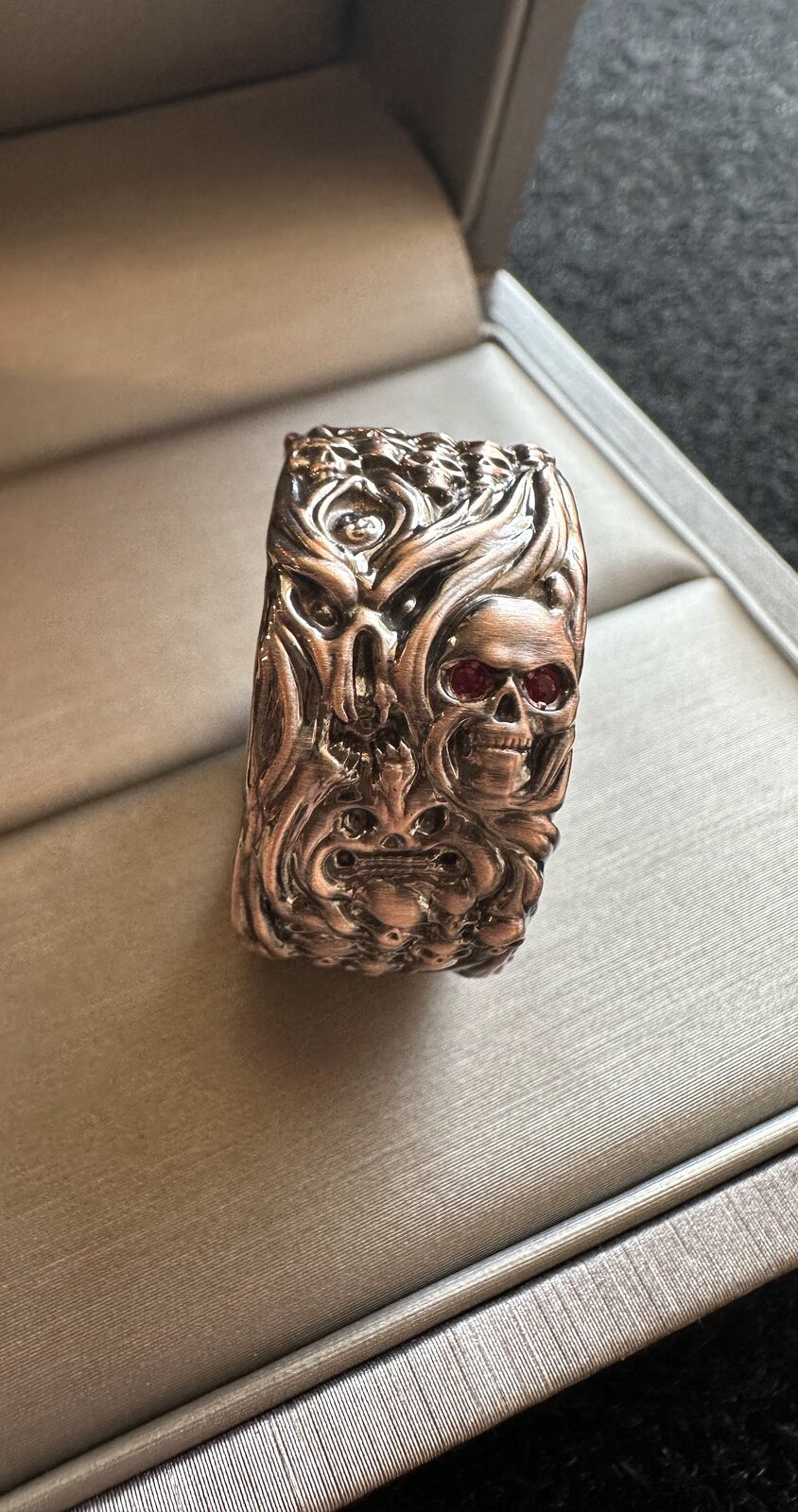 Ornate ring displayed upright in a jewelry box