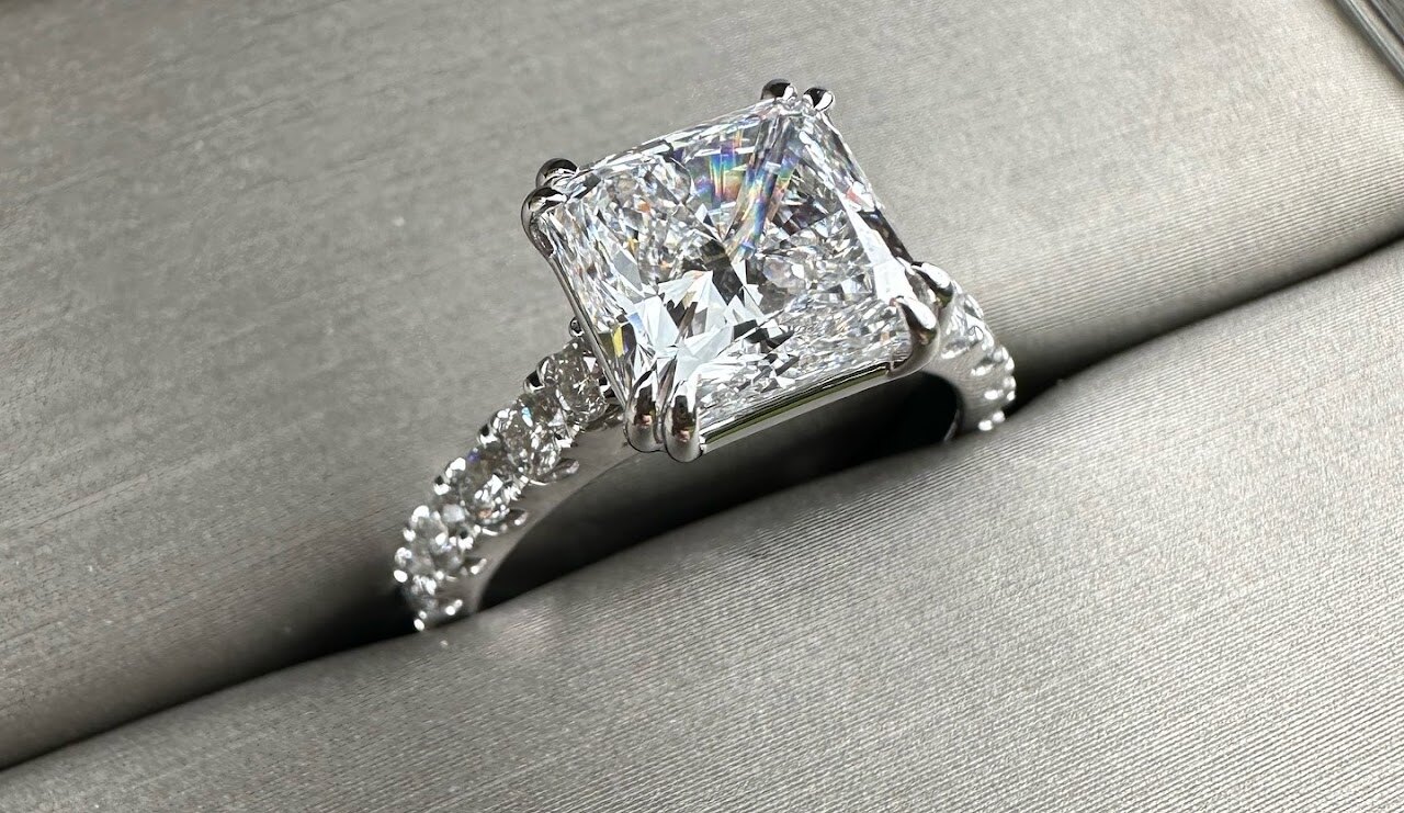 Square diamond engagement ring photographed on fabric