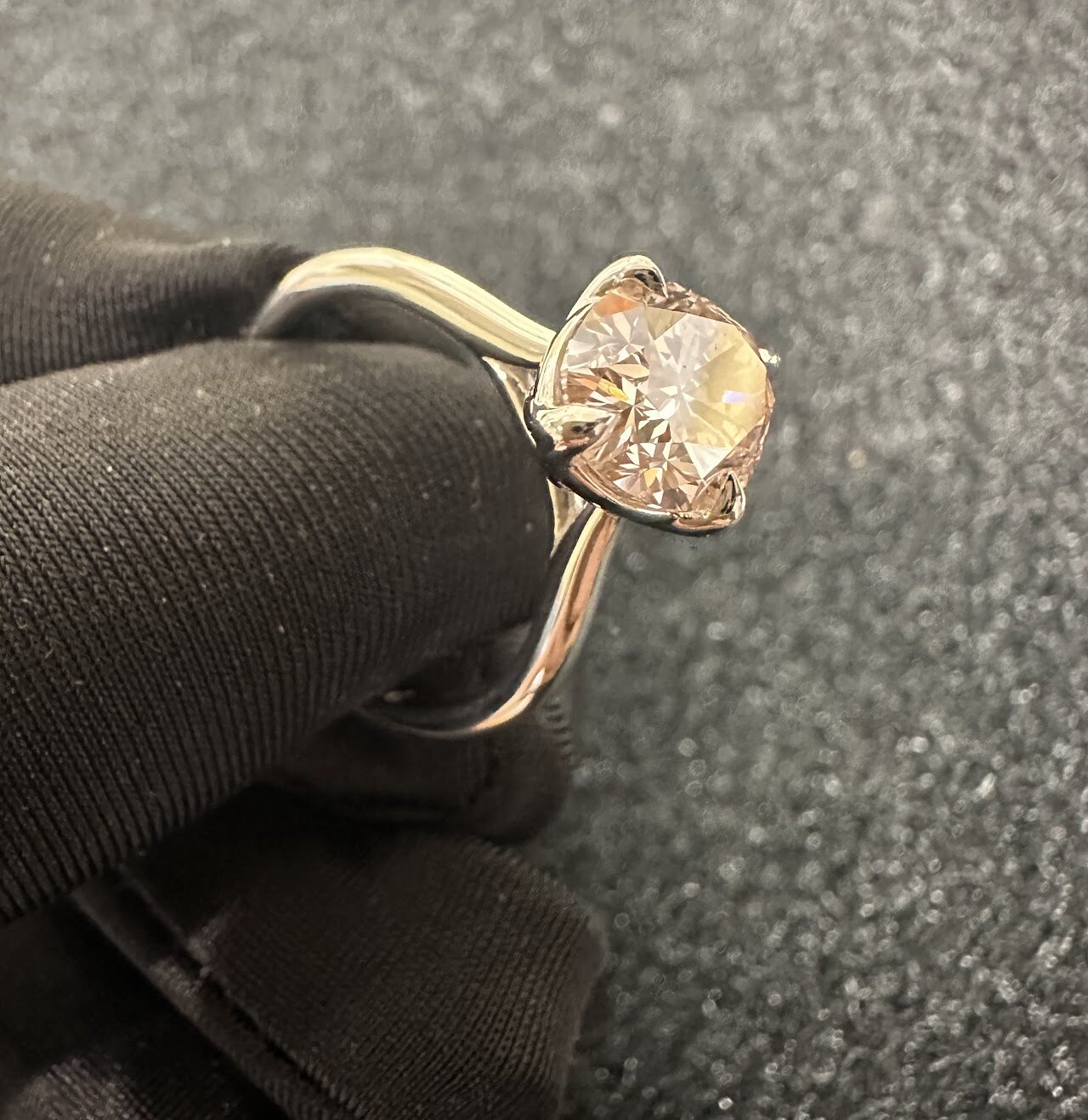 Warm center stone ring shown on dark fabric
