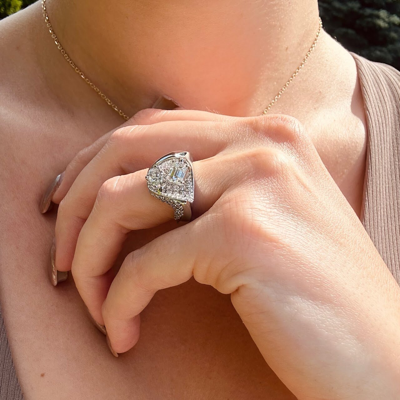 Custom engagement ring worn close to the heart in warm natural light