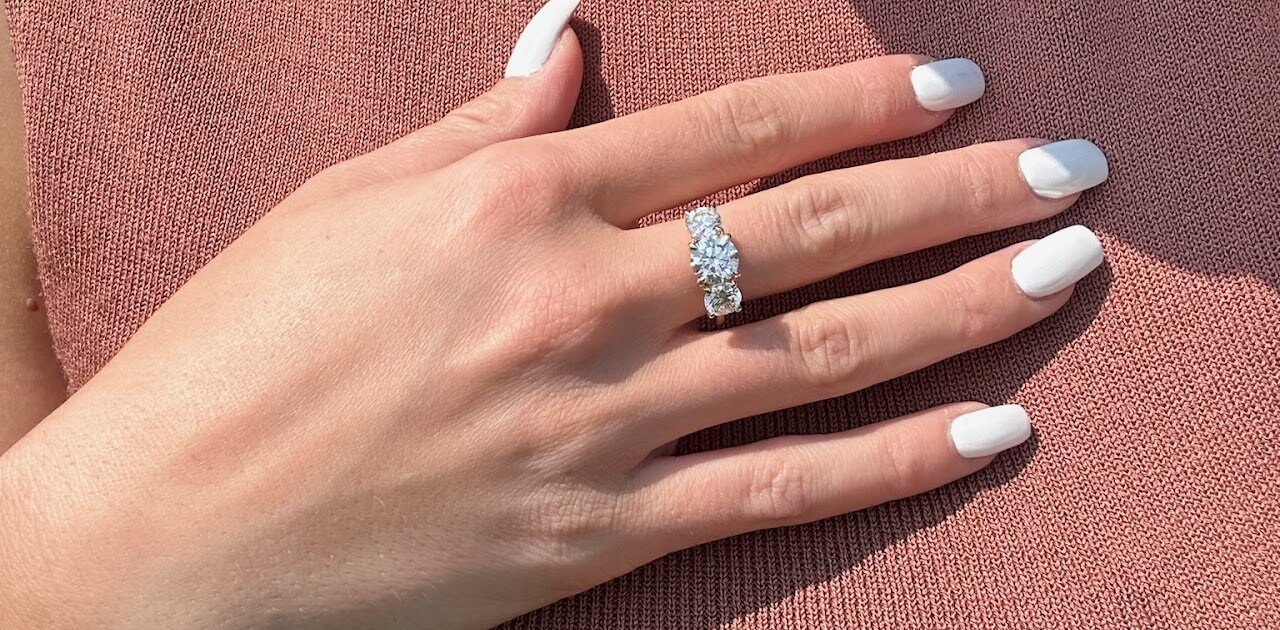 Wedding rings on hand against warm fabric