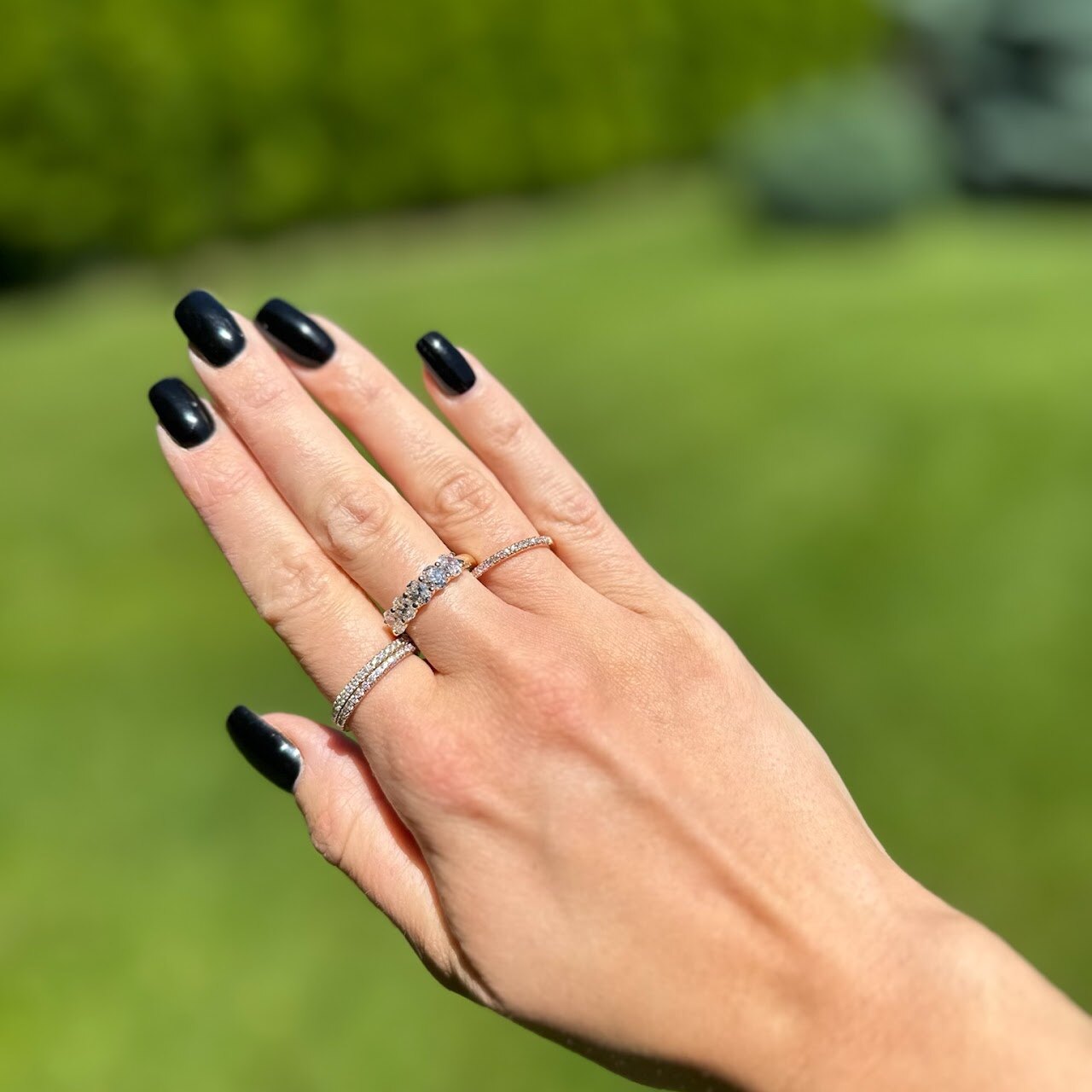 Rings worn outdoors on hand with green background