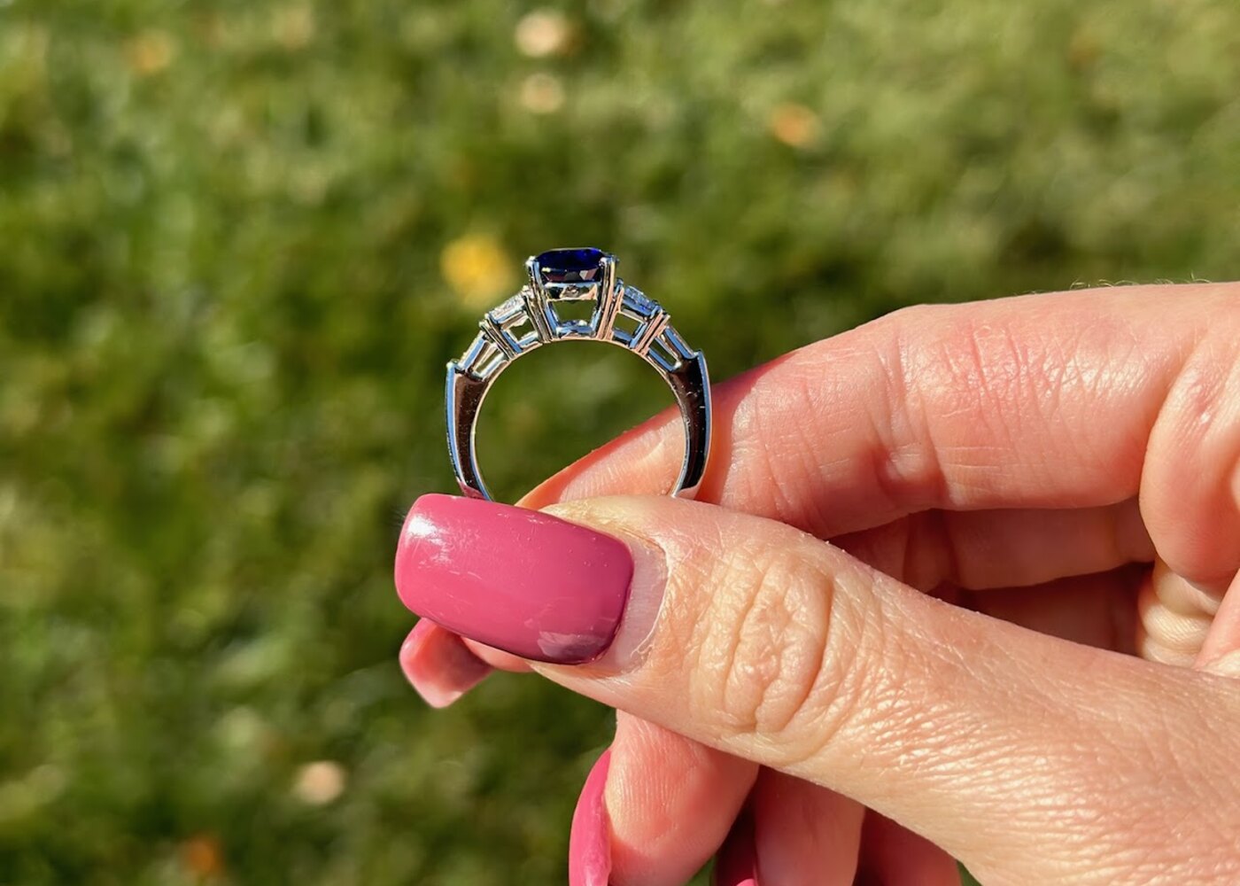 Custom engagement ring held outdoors